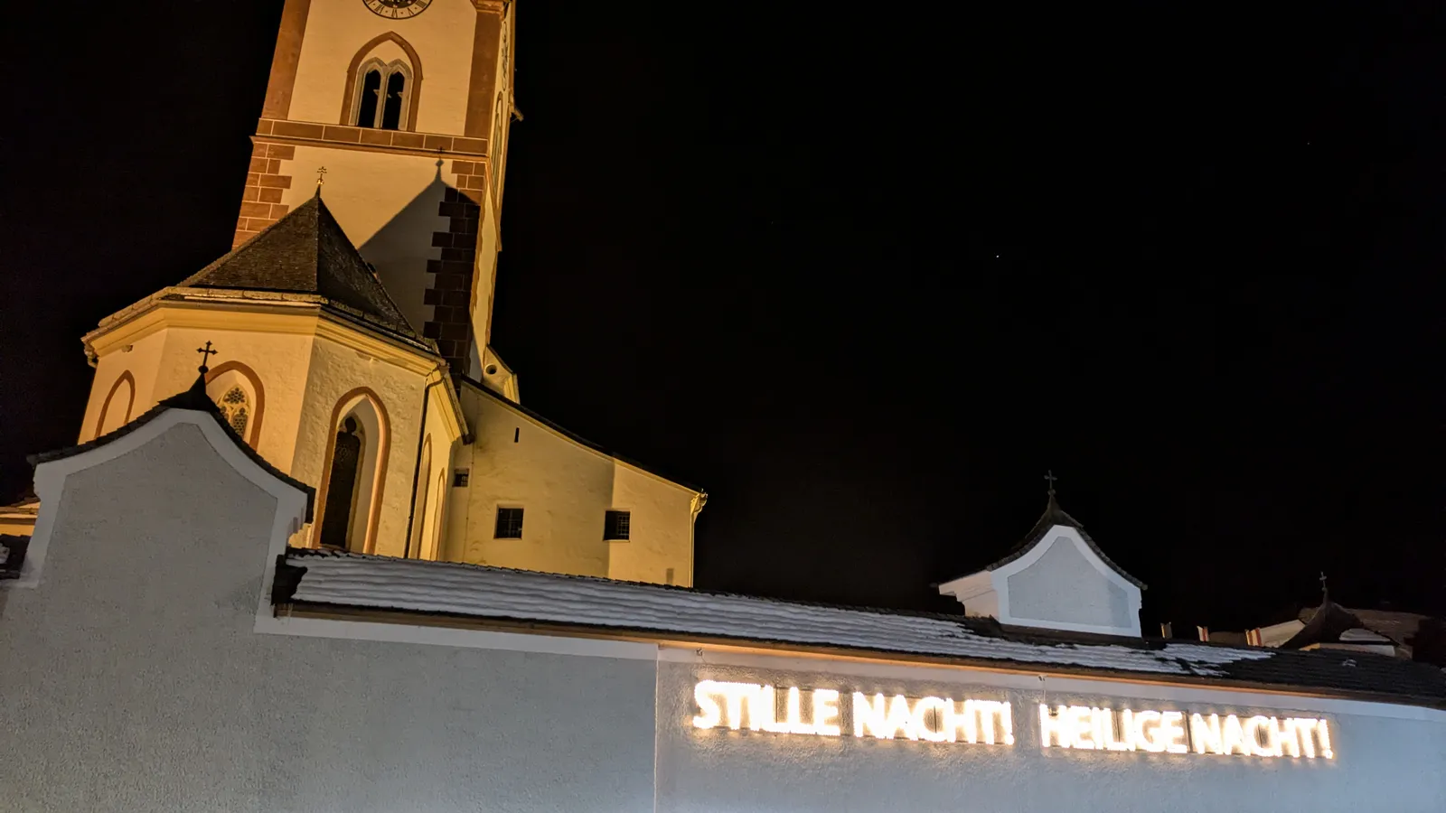 Illuminated church facade at night in Mariapfarr