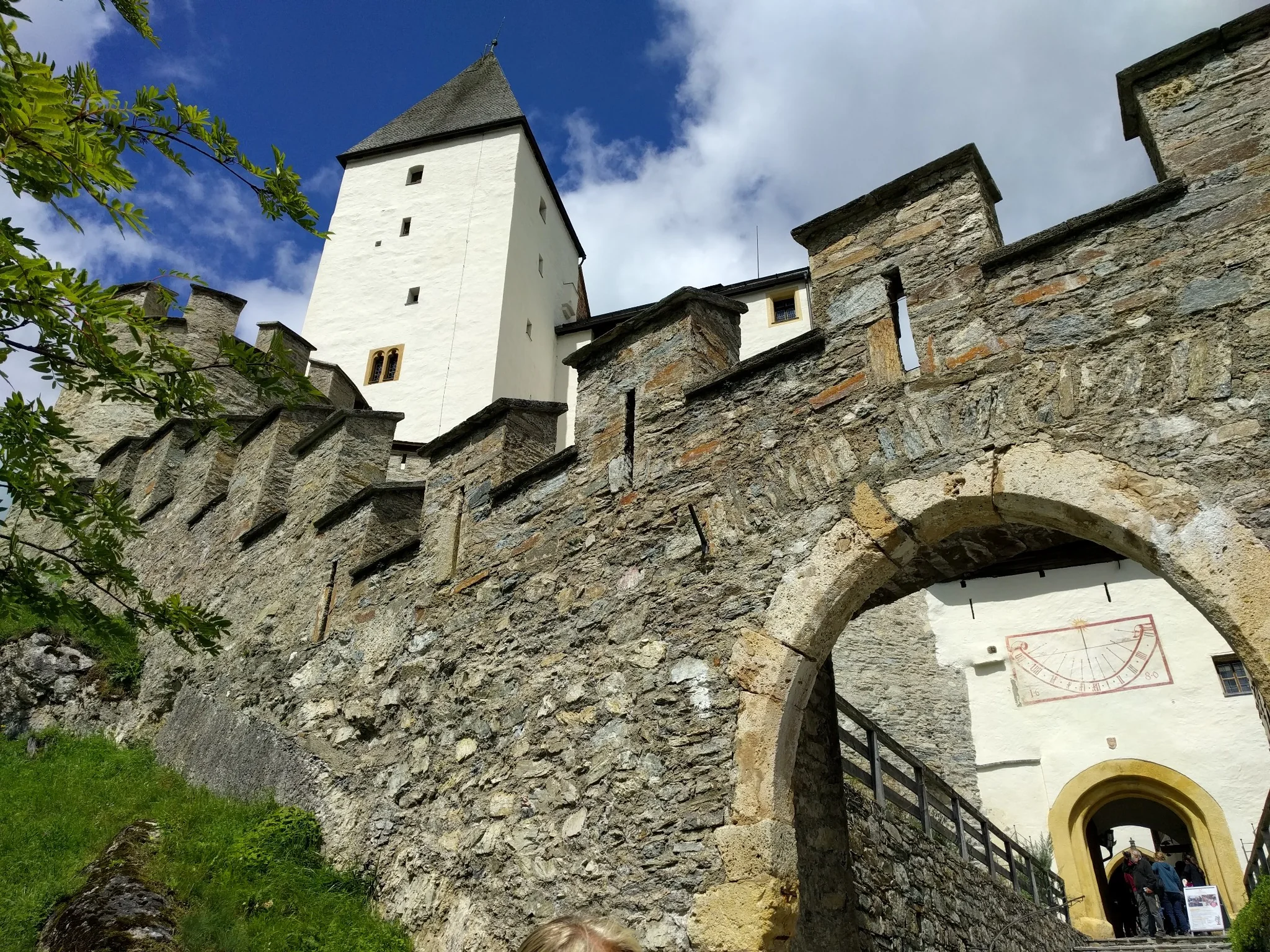 Stone walls and tower of Mauterndorf Castle in Lungau under a blue sky.