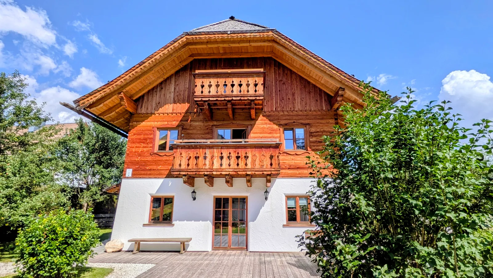 Exterior view of Samspitze 4 chalet surrounded by green alpine mountains in summer
