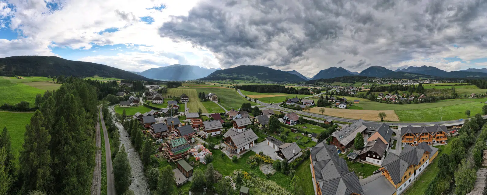 Aerial panorama of a Lungau village with green fields and mountains
