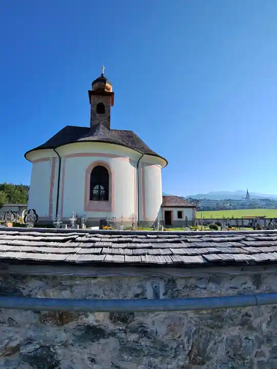 Pilgrimage church and cemetery in Mariapfarr under a clear blue sky.